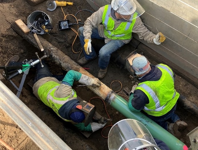 nh home propane Three construction workers repairing underground pipes in excavated trench
