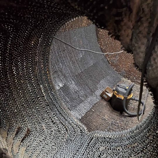 Industrial vacuum inside large metal ball-filled tank