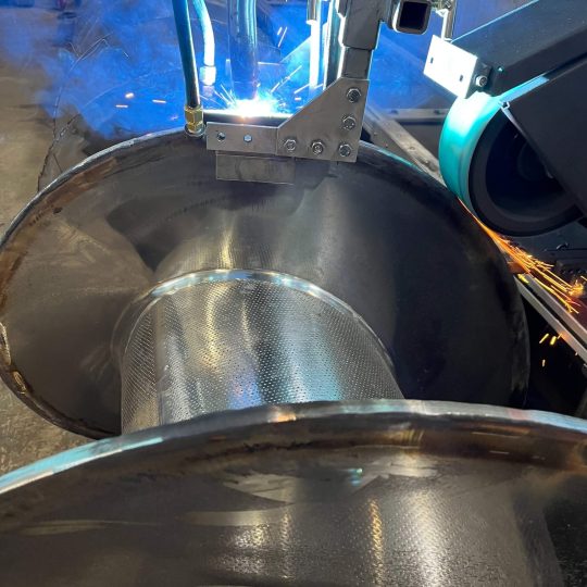 Automated welding inside large industrial metal vessel with sparks